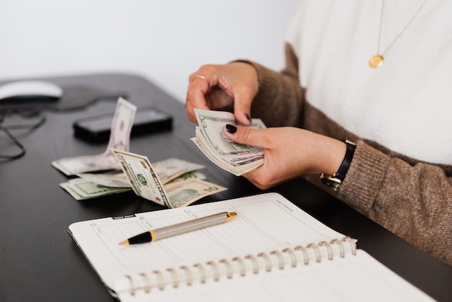 counting money near a notebook